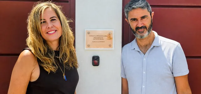 Ángela y Jesús junto a la placa de la entrada de la consulta: "Consulta de Psicología Clínica, Ángela Gutiérrez Gea, Jesús Martínez Martínez"